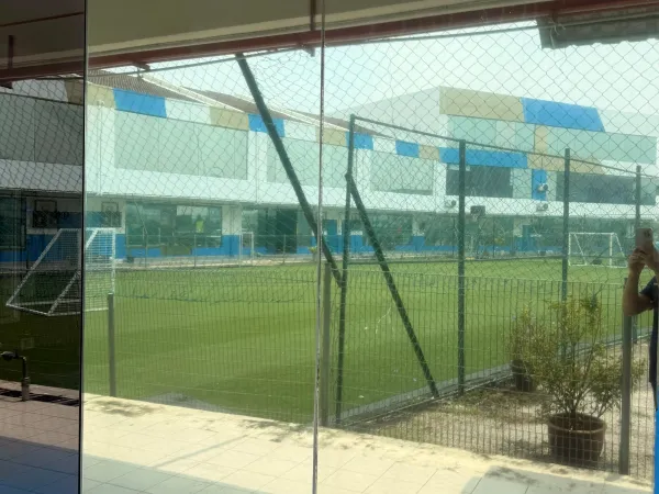 International school classroom exterior corridor with silver one-way privacy solar film overlooking field