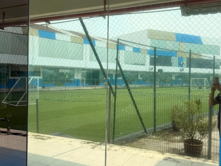 International school classroom exterior corridor with silver one-way privacy solar film overlooking field